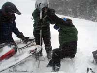 Workers struggle to free snowmobile stuck in deep snow near Buffalo Pass, Colo.