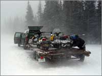 Workers load snowmobiles for departure in blizzard near Old Battle, Wyo.