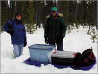 Workers prepare to haul snow samples away from site at West Yellowstone, Mont.